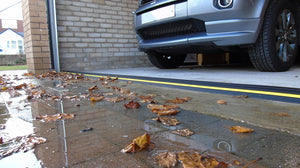 An installed 40mm garage door threshold seal water barrier blocking out rain and leaves