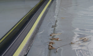 Close up of an applied 50mm Garage door flood barrier stopping water and leaves