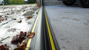 A close up of an installed 40mm garage door water barrier stopping leaves and water from entering