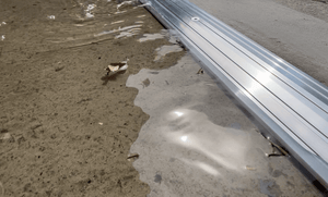 Close up of a 15mm commercial door threshold seal holding back water from entering a warehouse