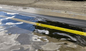 Garage door flood barrier holding back approximately 50mm of rainfall