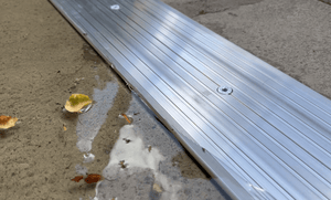 Close up of a industrial strength aluminium threshold stopping water and leaves from entering garage